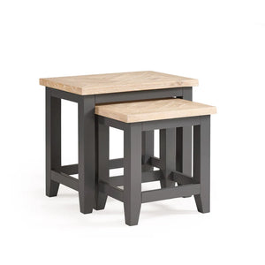 Set of two nesting tables with wooden tops and black frames on a white background