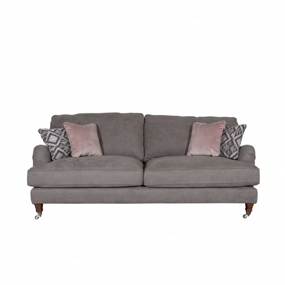 Gray sofa with patterned and solid color cushions on a white background