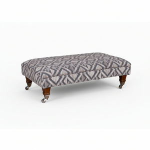 Patterned ottoman with wooden legs on a white background