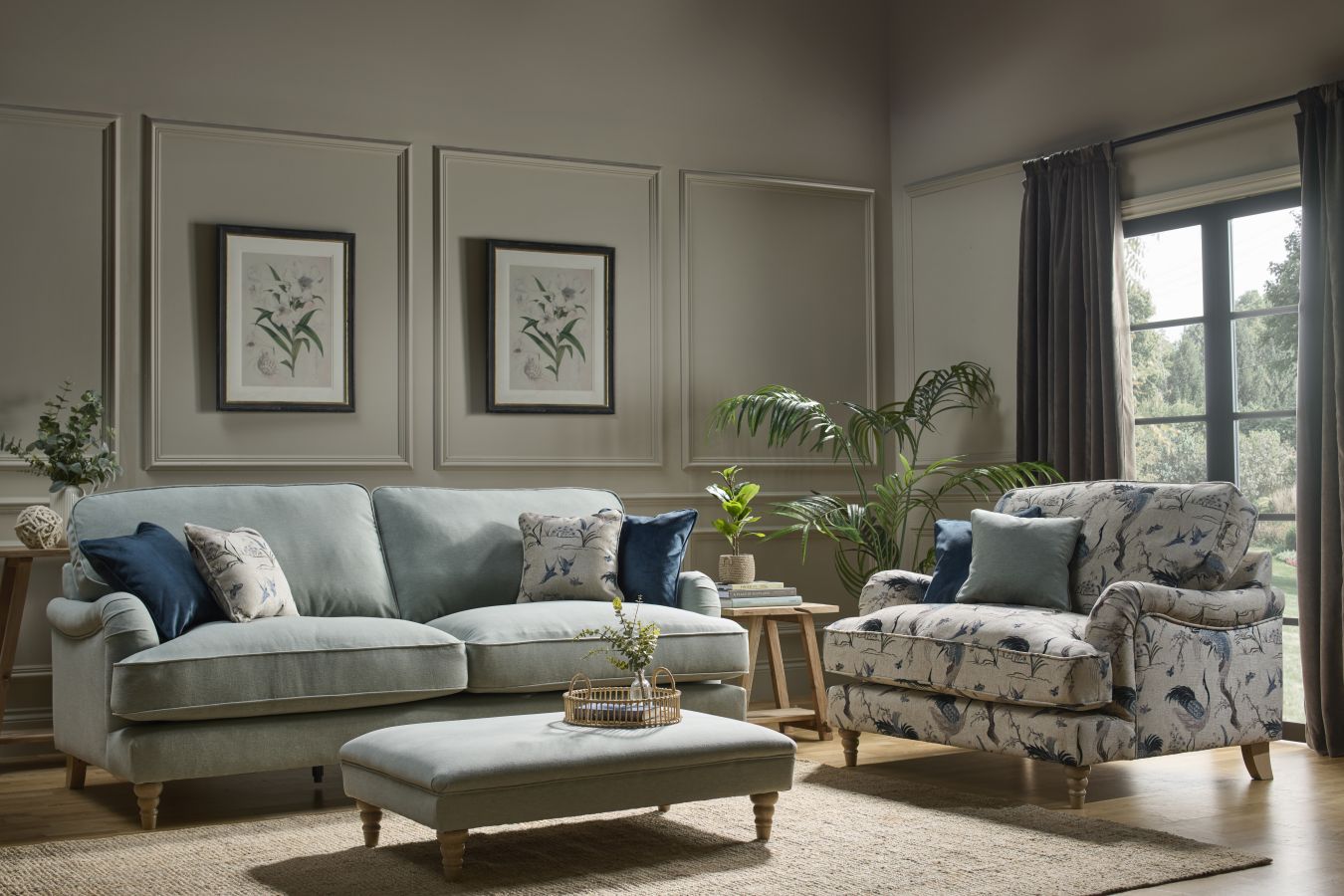 Living room with a gray sofa, patterned armchair, and ottoman.