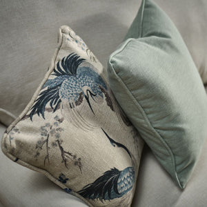 Decorative pillow with bird design on a gray sofa
