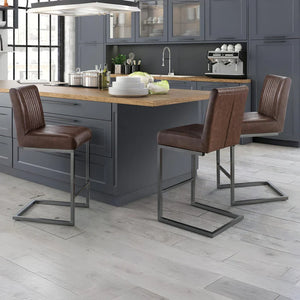 Modern kitchen with gray cabinets, wooden island, and brown bar stools.