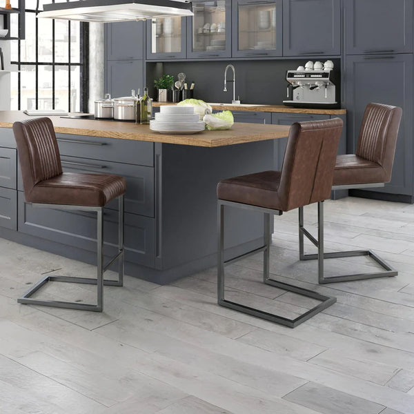 Modern kitchen with gray cabinets, wooden island, and brown bar stools.