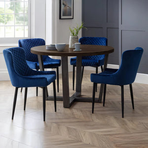 Dining room with a round wooden table and blue chairs.