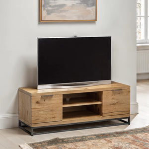 Wooden TV stand with a television on it in a room with a painting on the wall.