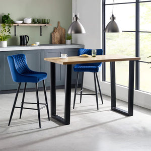 Modern kitchen with a wooden dining table and blue bar stools.