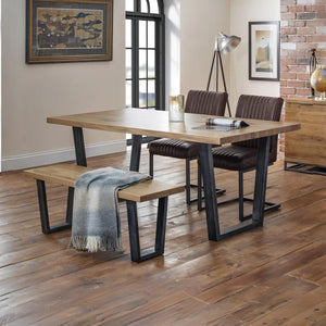 Dining area with wooden table, chairs, and bench on a wooden floor.