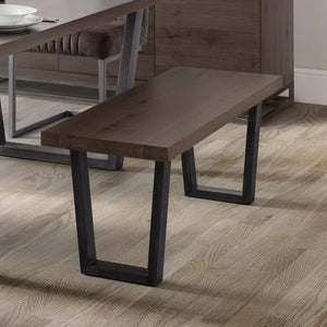 Wooden bench with black metal legs on a wooden floor
