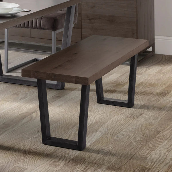 Wooden bench with black metal legs on a wooden floor