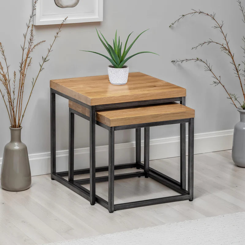 Set of two wooden nesting tables with black metal frames on a white background