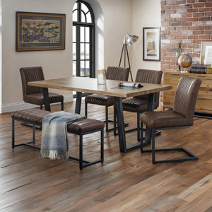 Dining room with wooden table and chairs, brick wall, and large window.