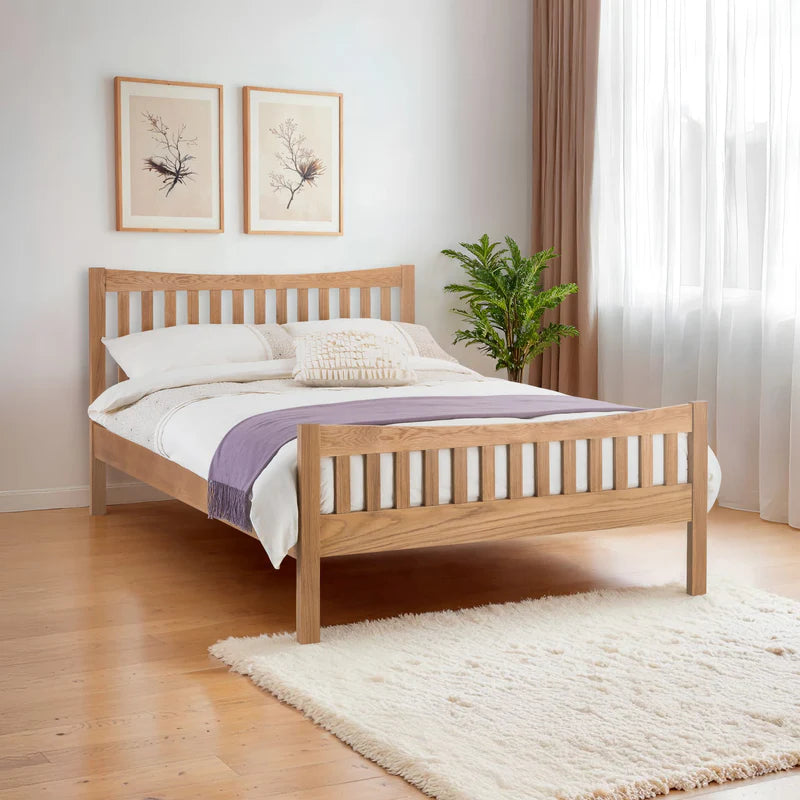 Wooden bed with white bedding and a purple blanket on a white background