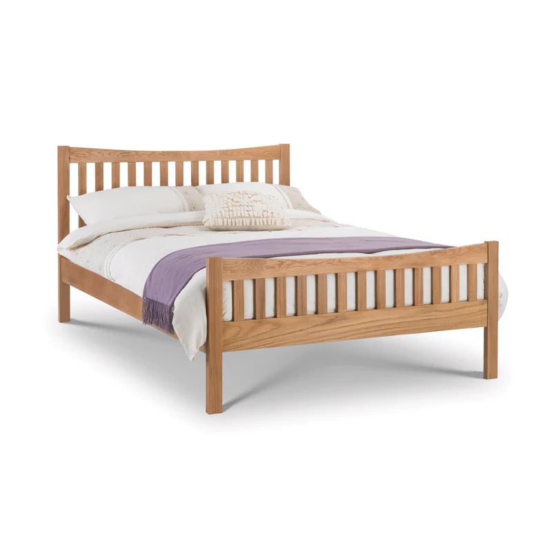 Wooden bed with white bedding and a purple blanket on a white background