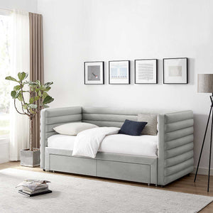 Gray upholstered bed with white bedding in a room with framed art on the wall.
