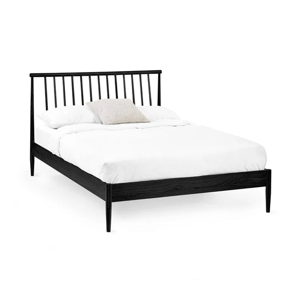 Black metal bed frame with white mattress on a white background