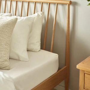Wooden bench with cushions against a neutral wall