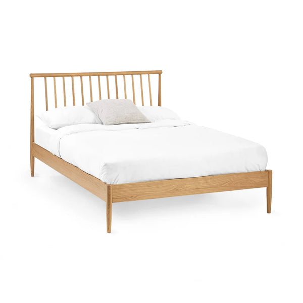 Wooden bed frame with white bedding on a white background
