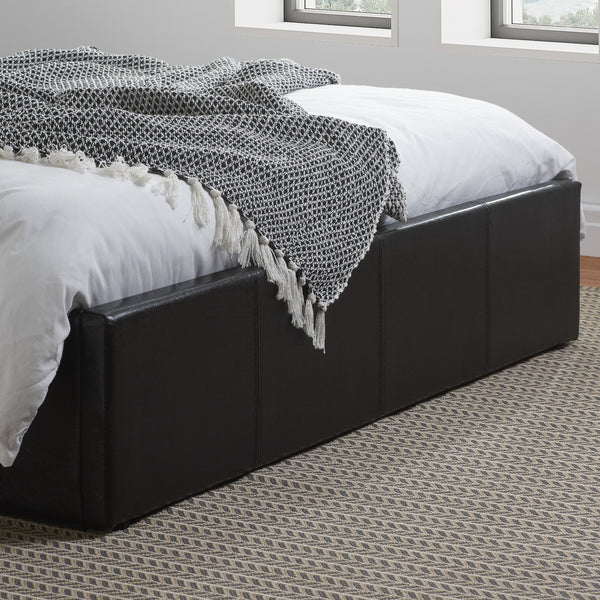 Bed with black upholstered headboard and white bedding in a room with windows.