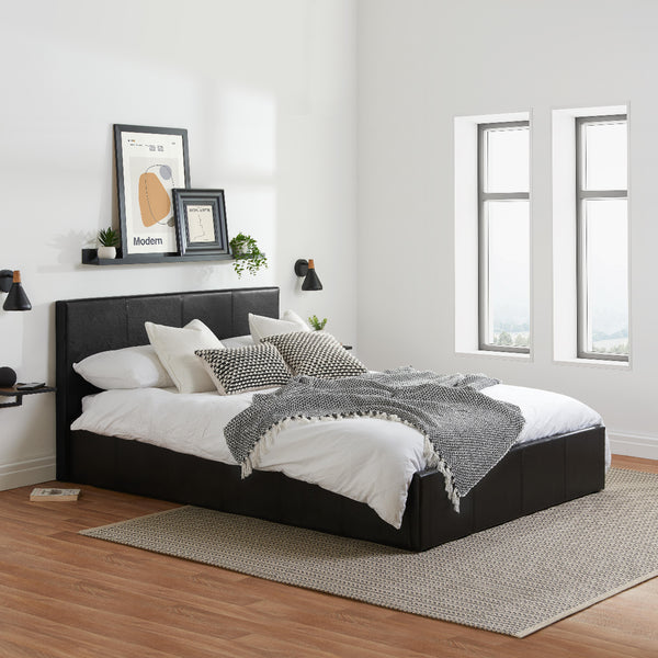 Modern bedroom with a black upholstered bed, white bedding, and decorative pillows.