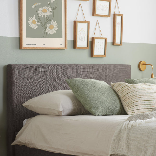Bedroom with a bed featuring pillows and a headboard, framed artwork on the wall.