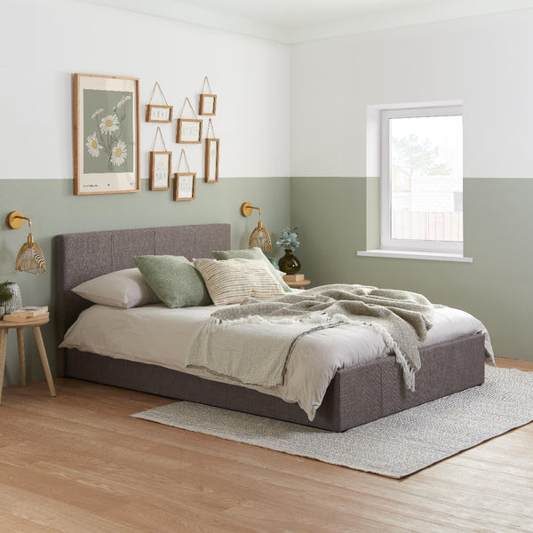 Neatly made bed in a bedroom with decorative elements and a window.