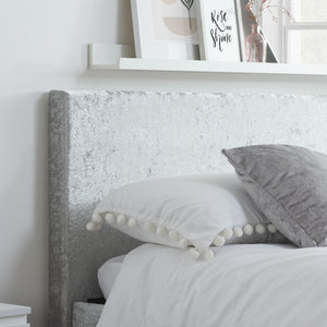 Gray textured headboard with white bedding and gray pillows in a bedroom setting.
