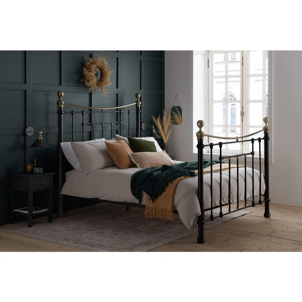 Bedroom with a black metal bed frame, white bedding, and decorative pillows.