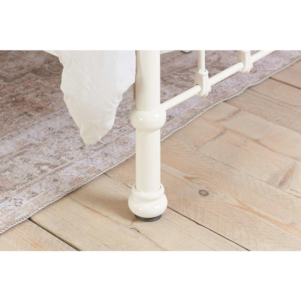 White cbed leg on a wooden floor with a rug underneath