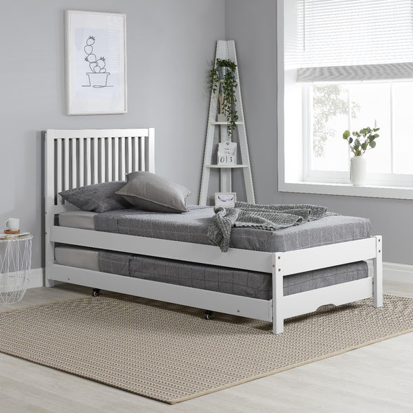 White bed frame with gray mattress in a room with a window and decorative items.