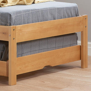 Wooden bed frame with a gray mattress on a wooden floor.