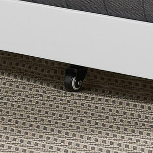 Close-up of a white piece of furniture with wheels on a textured carpet