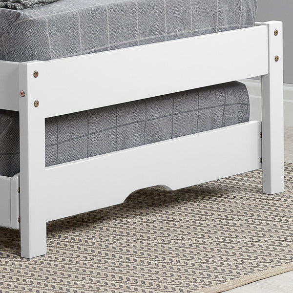 White bed frame with gray mattress on a patterned rug