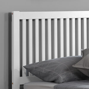 White wooden headboard with gray pillows against a gray wall