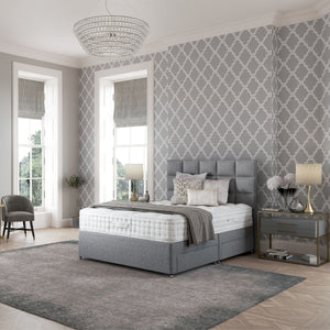 Modern bedroom with gray upholstered bed, patterned wallpaper, and decorative elements.