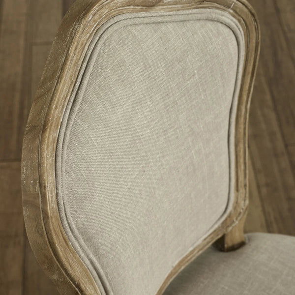 Close-up of a chair with wooden frame and beige fabric seat.