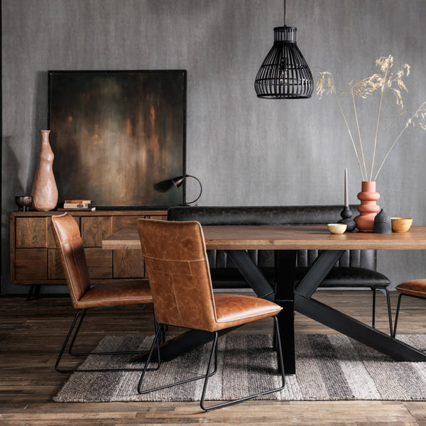 Dining area with wooden table and brown leather chairs against a gray wall.