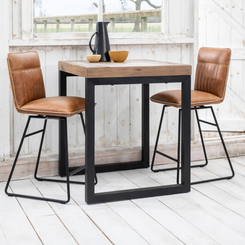 Brown leather bar stool with black metal legs on a white background
