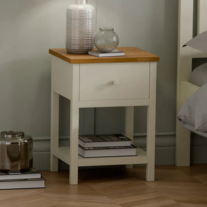 White nightstand with wooden top in a bedroom setting
