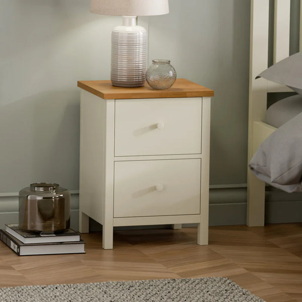 White nightstand with wooden top in a bedroom setting