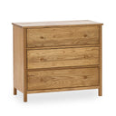  A three drawer chest in oak on a white background