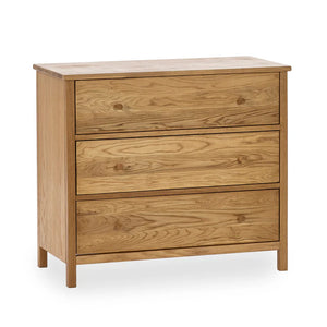  A three drawer chest in oak on a white background