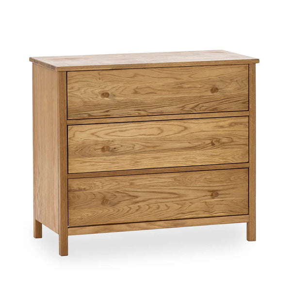 A three drawer chest in oak on a white background