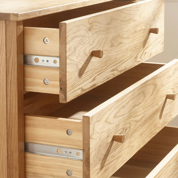 Wooden drawer unit with open drawers showing wooden handles.