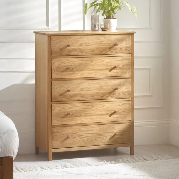 Wooden dresser with five drawers in a room setting