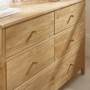 Wooden dresser with six drawers in a bedroom setting