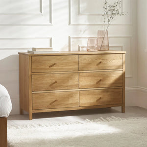 Wooden dresser with sixdrawers in a bedroom setting