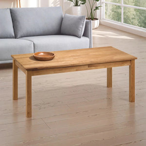 Wooden coffee table in a living room with a gray sofa and plants.