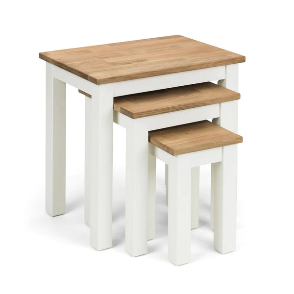 Set of three nesting tables with wooden tops and white bases on a white background