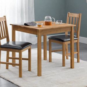 Wooden dining table with chairs and drinks on a light rug