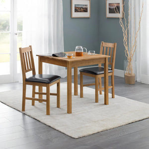 Wooden dining table with chairs in a room with a gray wall and white curtains.